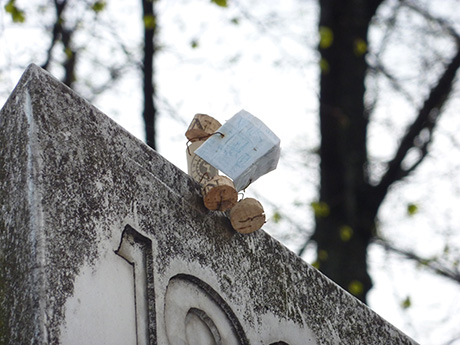 Korkmännchen liest Zeitung auf Steinmauer